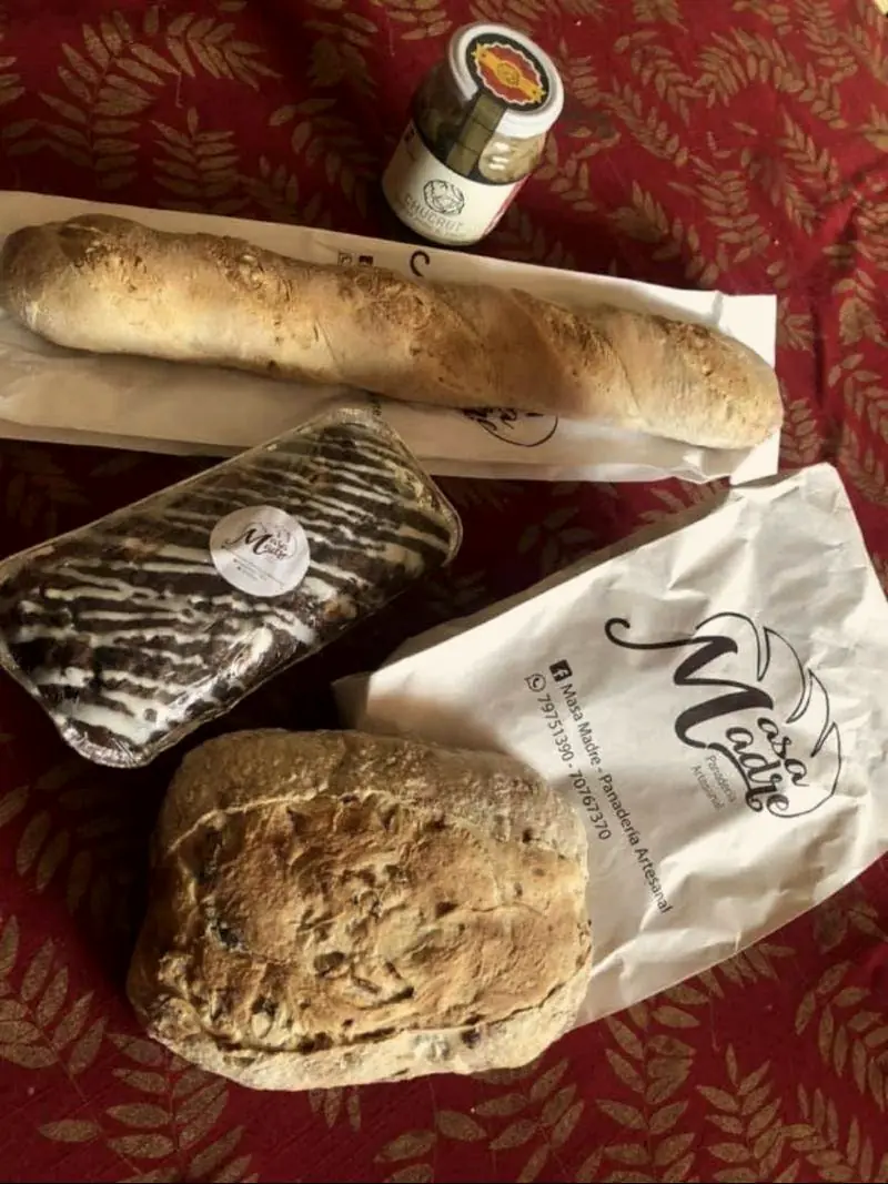 Baguette y pan con pasas en las bolsas de papel de Masa Madre.