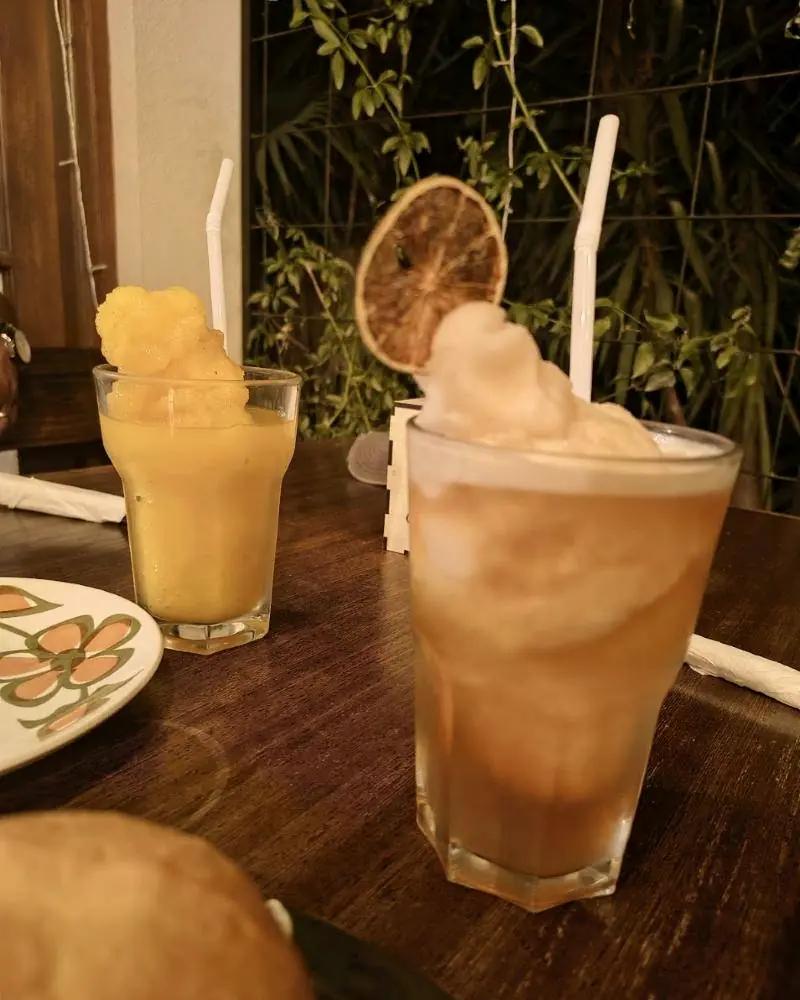 Bebidas frías con naranja deshidratada, de noche, frente a las plantas del patio.