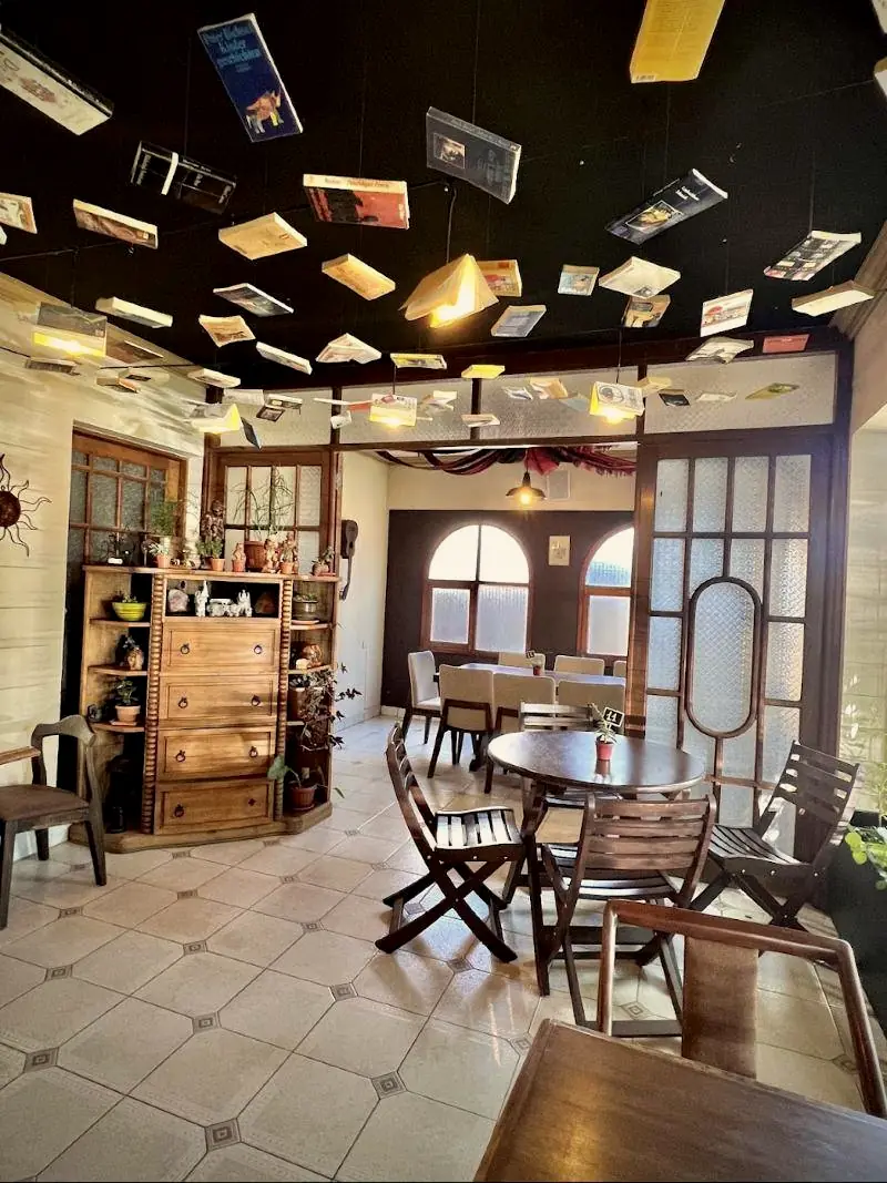Salón principal con cómoda antigua, plantas y libros flotantes.