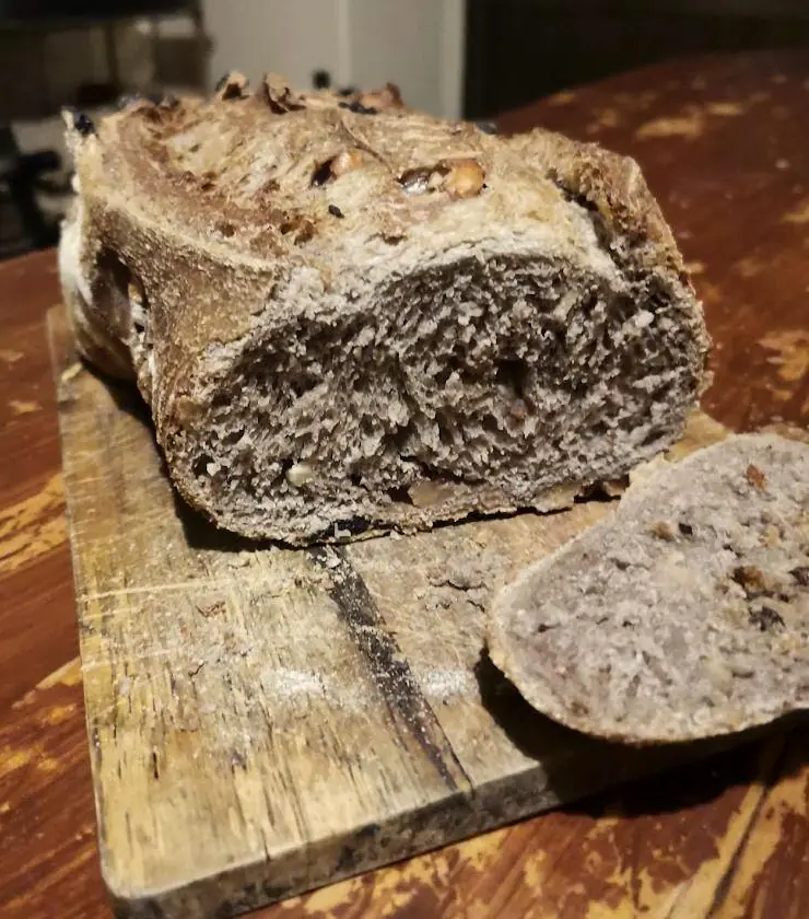 Pan de centeno con nueces recién cortado sobre una tabla de madera.